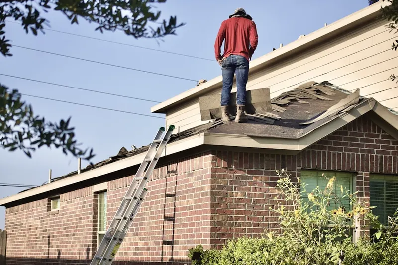 Professional roofer working on a residential roof in Lincoln School